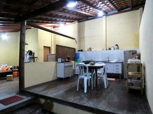 kuchnia ze stołem i krzesłami w pokoju w obiekcie Vila do Surfe w mieście Ubatuba