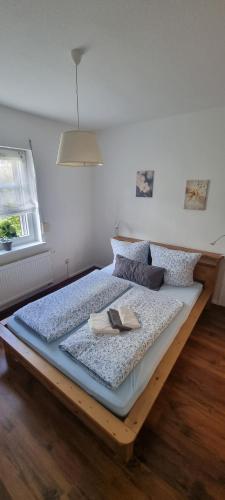 1 dormitorio con 1 cama grande con marco de madera en Ferienhaus Schuldienersch, en Biedenkopf