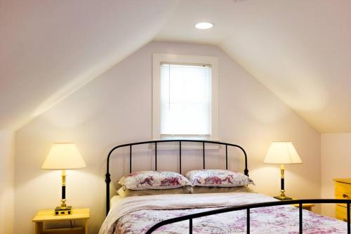 a bedroom with a bed with two lamps and a window at 3BR Beautiful Remodeled Victorian BEACH LOCKER in Ocean Grove