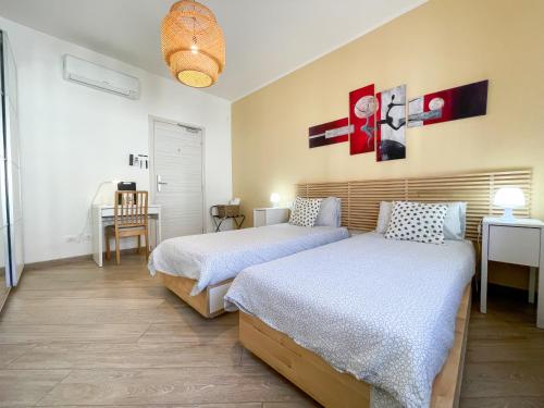1 dormitorio con 2 camas y mesa en MilanHolidays, en Milán