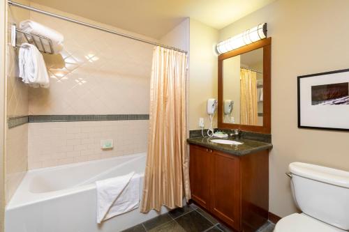 a bathroom with a tub and a toilet and a sink at The Village at Palisades Tahoe in Olympic Valley