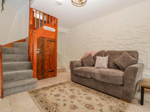 a living room with a couch and a staircase at The Cwtch in Abergavenny
