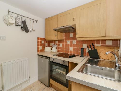 a kitchen with a sink and a stove top oven at The Cwtch in Abergavenny