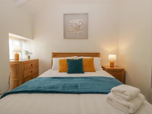 The Cwtch في أبرجافني: غرفة نوم مع سرير كبير مع الوسائد الزرقاء والبرتقالية