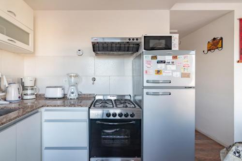 a kitchen with a stove and a refrigerator at Los Asturianos APART amentos 3 in Mar del Plata