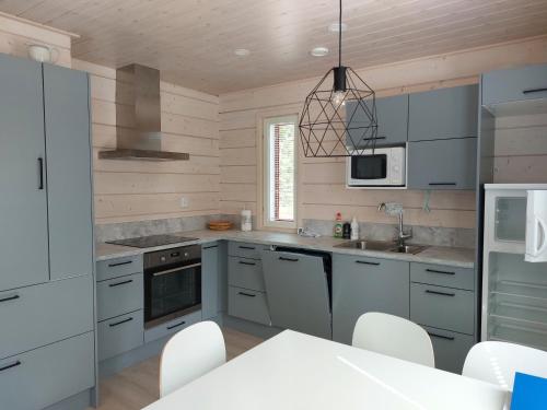 una cucina con armadietti grigi ed elettrodomestici bianchi di Villa Ruskamaja ad Äkäslompolo
