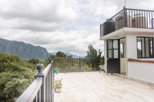 a house with a balcony with a view of the mountains at CASA ANTARES in Tepoztlán