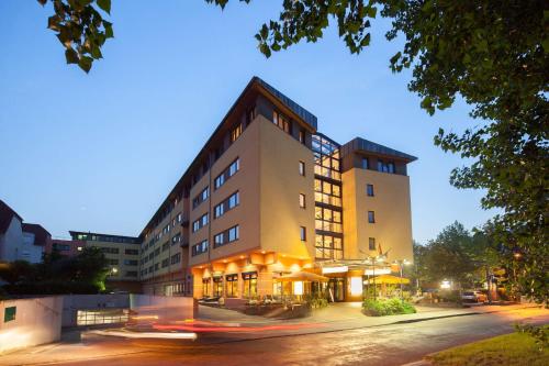 a building on a street in a city at night at Suite Hotel Leipzig in Leipzig