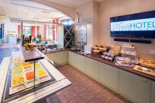a restaurant with a counter with food on it at Suite Hotel Leipzig in Leipzig