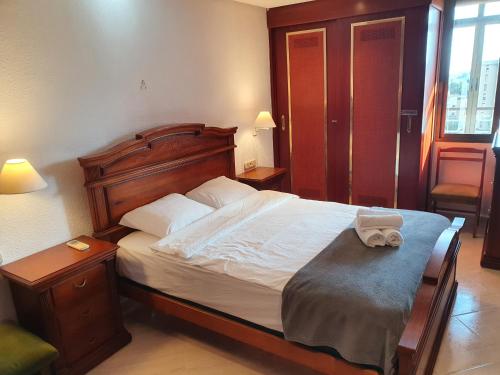 Schlafzimmer mit einem großen Bett mit einem Kopfteil aus Holz in der Unterkunft Nogalera Sea&Sun Apartment in Torremolinos