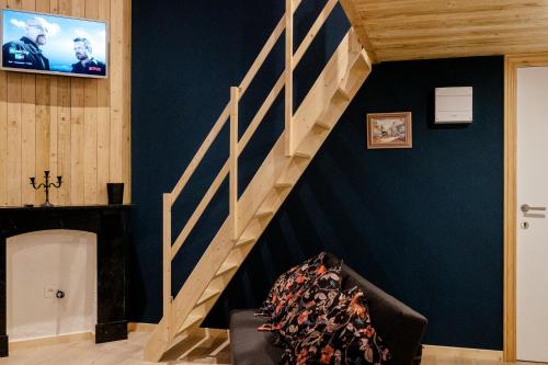 a living room with a staircase and a tv at Le Studio Émeraude - Topdestination-Spa in Spa