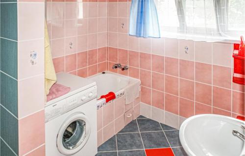 a bathroom with a washing machine and a sink at Stunning Home In Biskupiec With 4 Bedrooms And Wifi in Biesówko