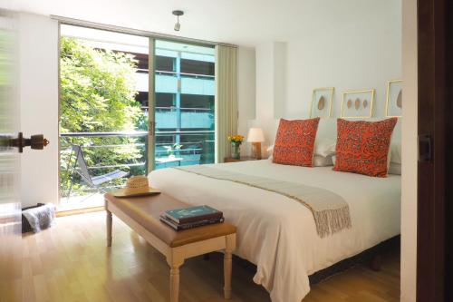 1 dormitorio con cama grande y ventana grande en Comfort Reforma By The Local Way, en Ciudad de México