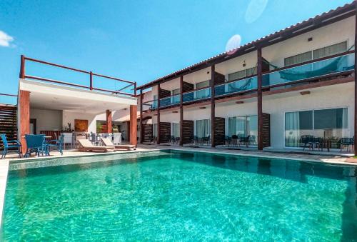 a swimming pool in front of a building at Caly Pousada in São Miguel do Gostoso