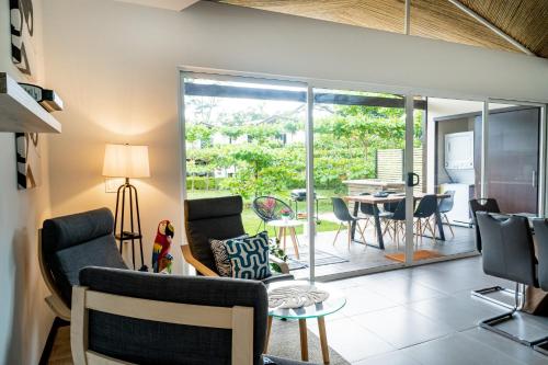 a living room with chairs and a table and a dining room at Ciudad del Mar 104 in Jacó