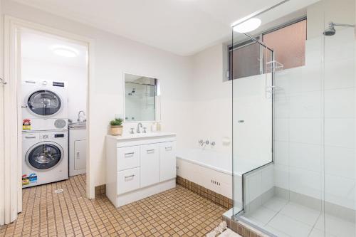 a bathroom with a sink and a washing machine at Thurlow Lodge, 7,6 Thurlow Avenue - Beautifully styled unit with WiFi, views and a pool in Nelson Bay