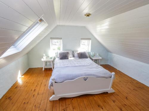 a bedroom with a white bed in a attic at Tigh Mhicheal Phaidin in Finny