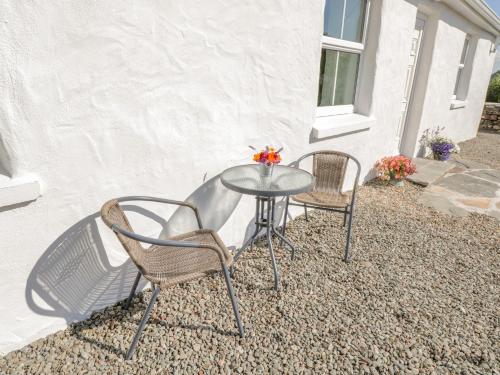 two chairs and a glass table on a patio at Tigh Mhicheal Phaidin in Finny