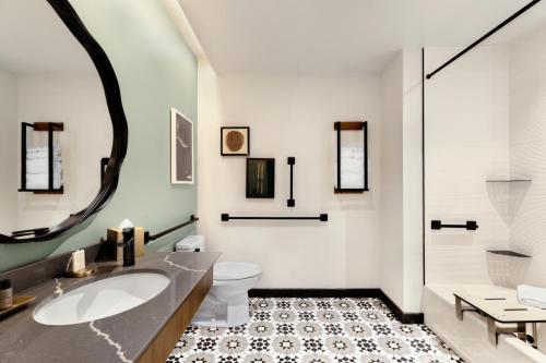 a bathroom with a sink and a toilet and a mirror at Indigo - Silverthorne, an IHG Hotel in Silverthorne