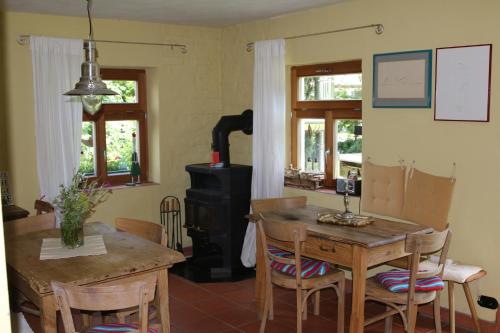 eine Küche mit einem Holzofen, einem Tisch und Stühlen in der Unterkunft Bio Pension Kirschenfee in Sontheim