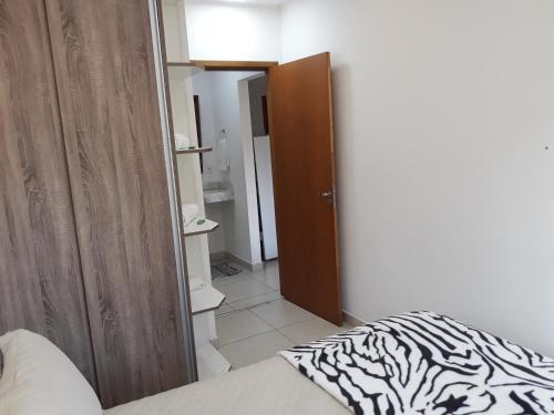 ein Schlafzimmer mit einem Bett, einem Schrank und einer Tür in der Unterkunft Aconchego e Requinte no Centro in Petrópolis