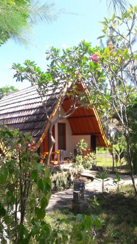 a small house with a thatched roof at Yoland Guesthouse in Gili Islands