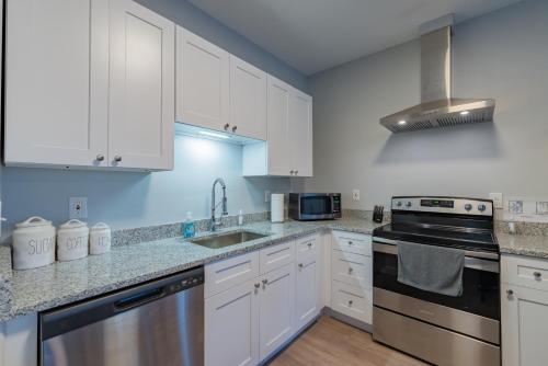 a kitchen with white cabinets and stainless steel appliances at Eastlawn Place cozy 2 bdrm townhome near downtown San Antonio in San Antonio