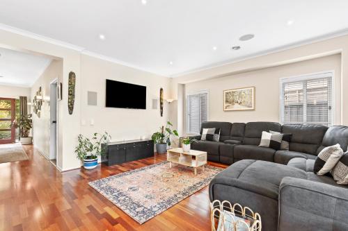 a living room with a couch and a tv at Parkview Curlewis- sleeping 12, close to wineries in Curlewis