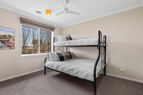 a bedroom with two bunk beds and a window at Parkview Curlewis- sleeping 12, close to wineries in Curlewis