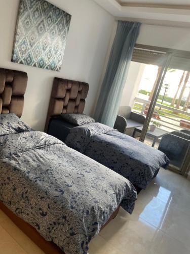 a bedroom with two beds and a window with a view at Costa beach in Bouznika