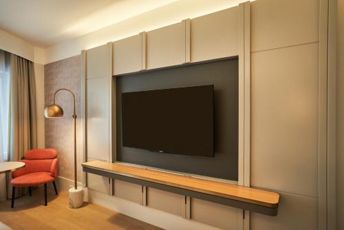 a living room with a flat screen tv on a wall at The Porter House Hotel Sydney - MGallery in Sydney