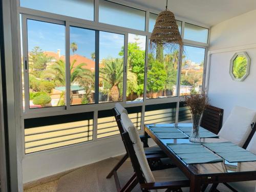 a dining room with a table and a large window at Charming & cosy beach apartment in Torremolinos
