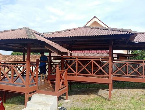 een houten paviljoen met een persoon erin bij Kampong Style Homestay Pengkalan Balak - Sea View in Pengkalan Balak