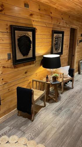 a log cabin with a table and a lamp and chairs at Hotel Palafito Entre Mar y Tierra in Castro