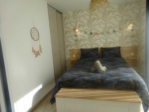 ein Schlafzimmer mit einem Bett mit einem Kopfteil aus Holz in der Unterkunft Gîte Saint-Georges-du-Bois, 2 pièces, 2 personnes - FR-1-410-336 in Rouillon