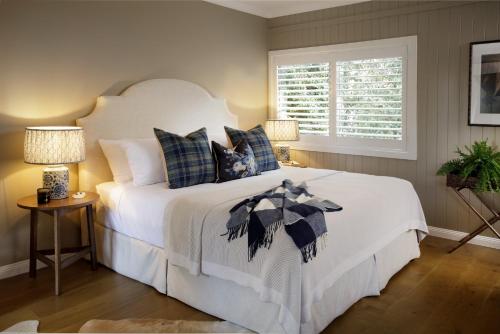 a bedroom with a large white bed with blue pillows at Verandah House Country Estate in Mount Tamborine