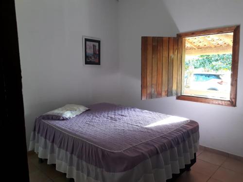 1 dormitorio con 1 cama en una habitación con ventana en Sítio Vista da Serra en Lavrinhas