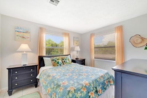 een slaapkamer met een bed en twee ramen bij Blissful Beach Retreat A in Englewood