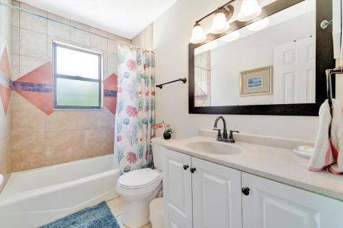 een badkamer met een wastafel, een toilet en een spiegel bij Blissful Beach Retreat A in Englewood