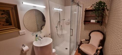 a bathroom with a shower and a sink and a mirror at Pheasant Lodge in Paparoa