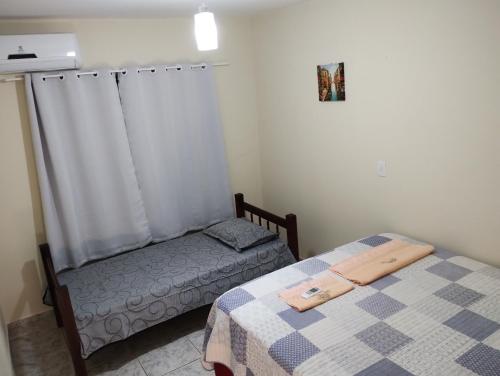 a small bedroom with two beds and a window at Casa com piscina próximo à Avenida das Cataratas in Foz do Iguaçu