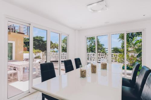 a white dining room with a table and chairs at Beachfront Art Villa Samui in Bophut 