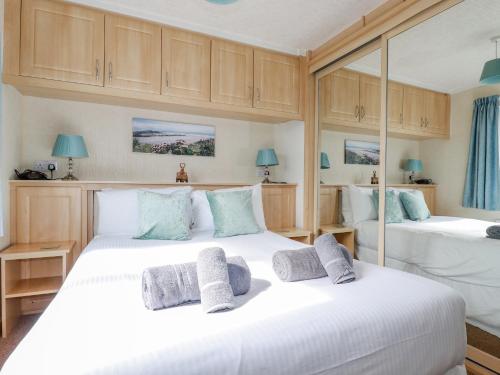 - une chambre avec 2 lits et des placards en bois dans l'établissement Chi Prenn Byhan, à Tintagel