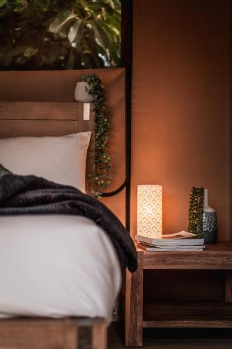 a bedroom with a bed and a side table with books at Poinciana at Cooee Bay in Yeppoon