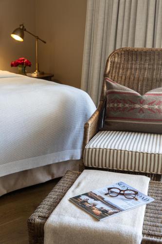 a bedroom with a bed and a chair with a book on it at Verandah House Country Estate in Mount Tamborine
