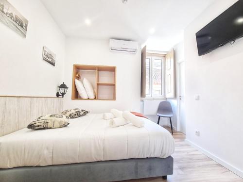 een witte slaapkamer met een groot bed in een kamer bij COIMBRA CITY CHARM in Coimbra