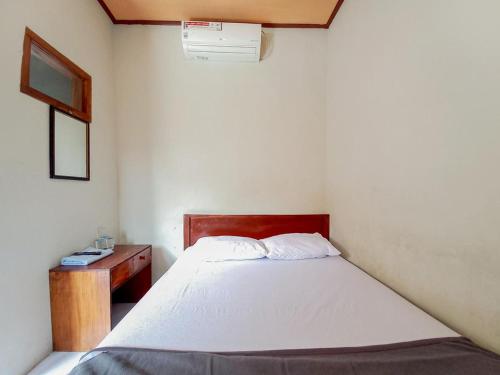 a small bedroom with a bed and a desk at Hotel Gerung 2 near Luwes Mall Nganjuk Mitra RedDoorz in Nganjuk