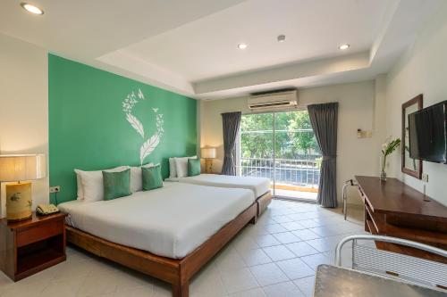 1 dormitorio con 1 cama grande y TV en Bella Villa Pattaya 3rd Road en Pattaya centro