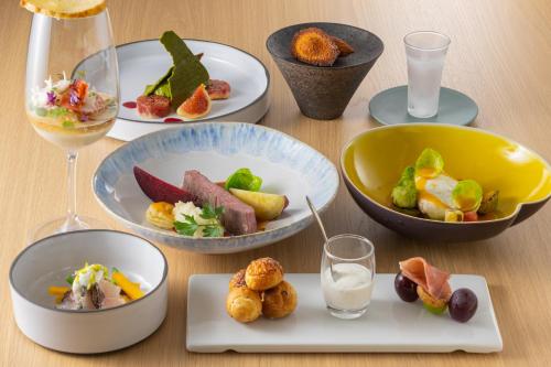 a table with plates of food and glasses of water at Hotel Lepo Chahal in Matsuyama