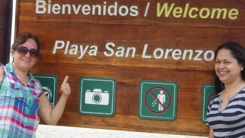 two women standing in front of a sign with a camera at Hostal Rosa Mar in Manta